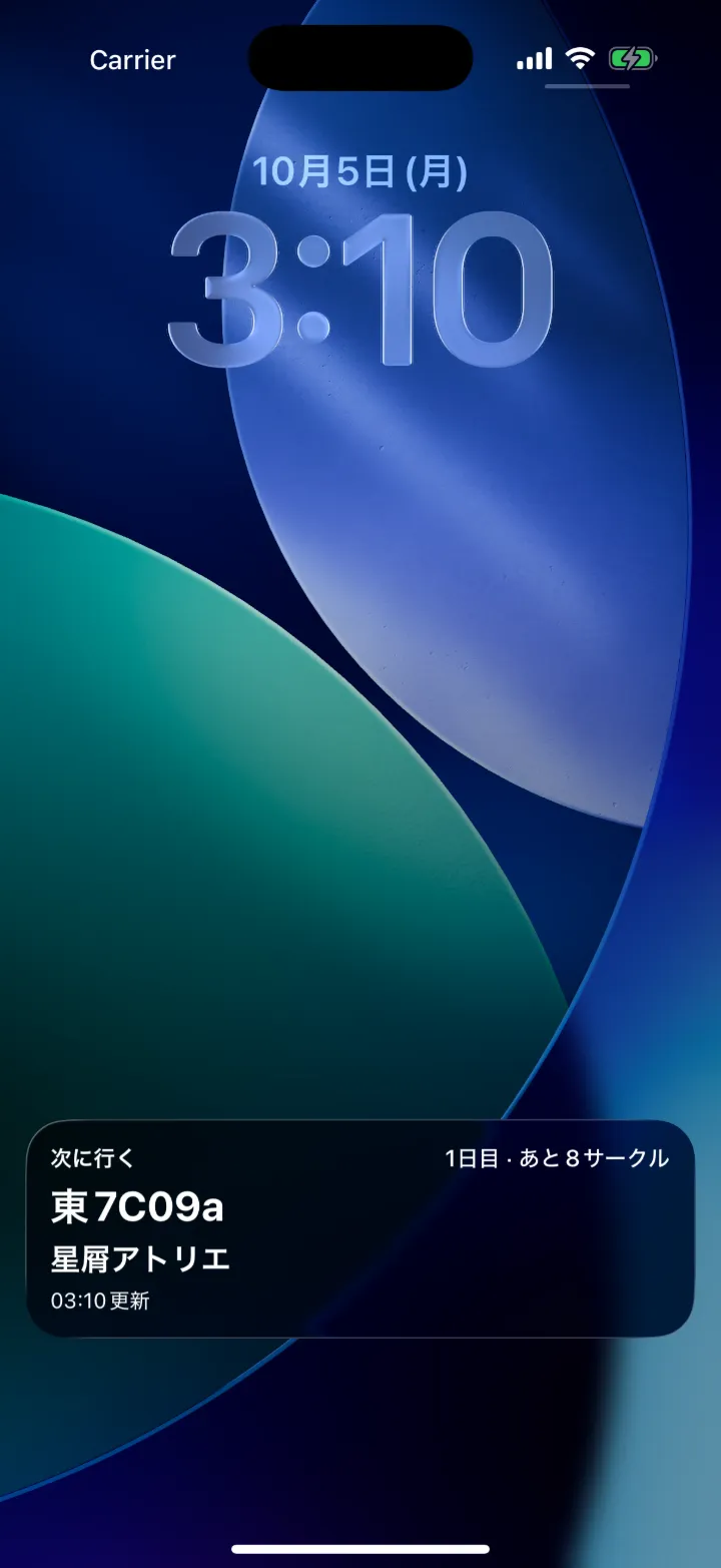 iPhoneのロック画面。ライブアクティビティに「次に行く 東7C09a 星屑アトリエ」「1日目・あと8サークル」と表示されている（架空のデータ）